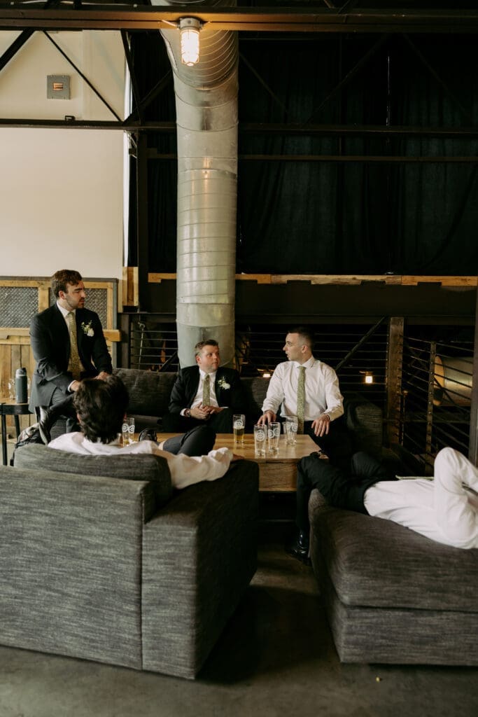 candid of groomsmen enjoying time together before wedding ceremony at highland brewing