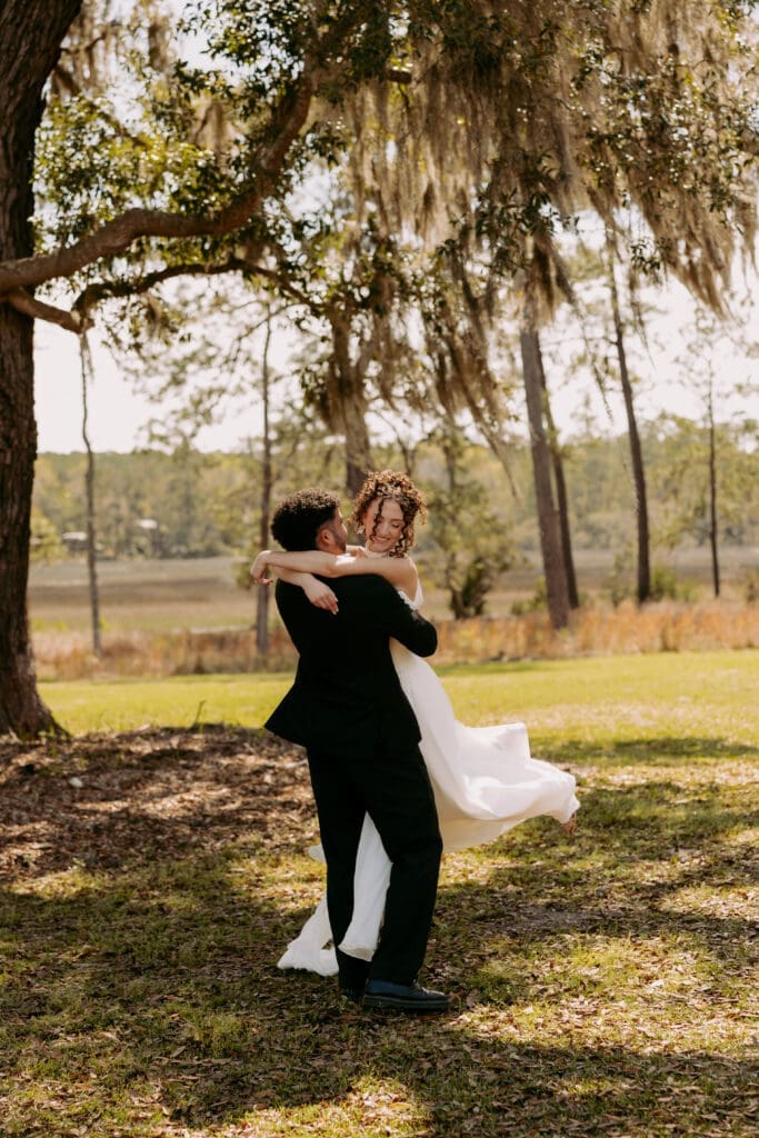 bride and groom twirling at pine creek place spanish moss tree 